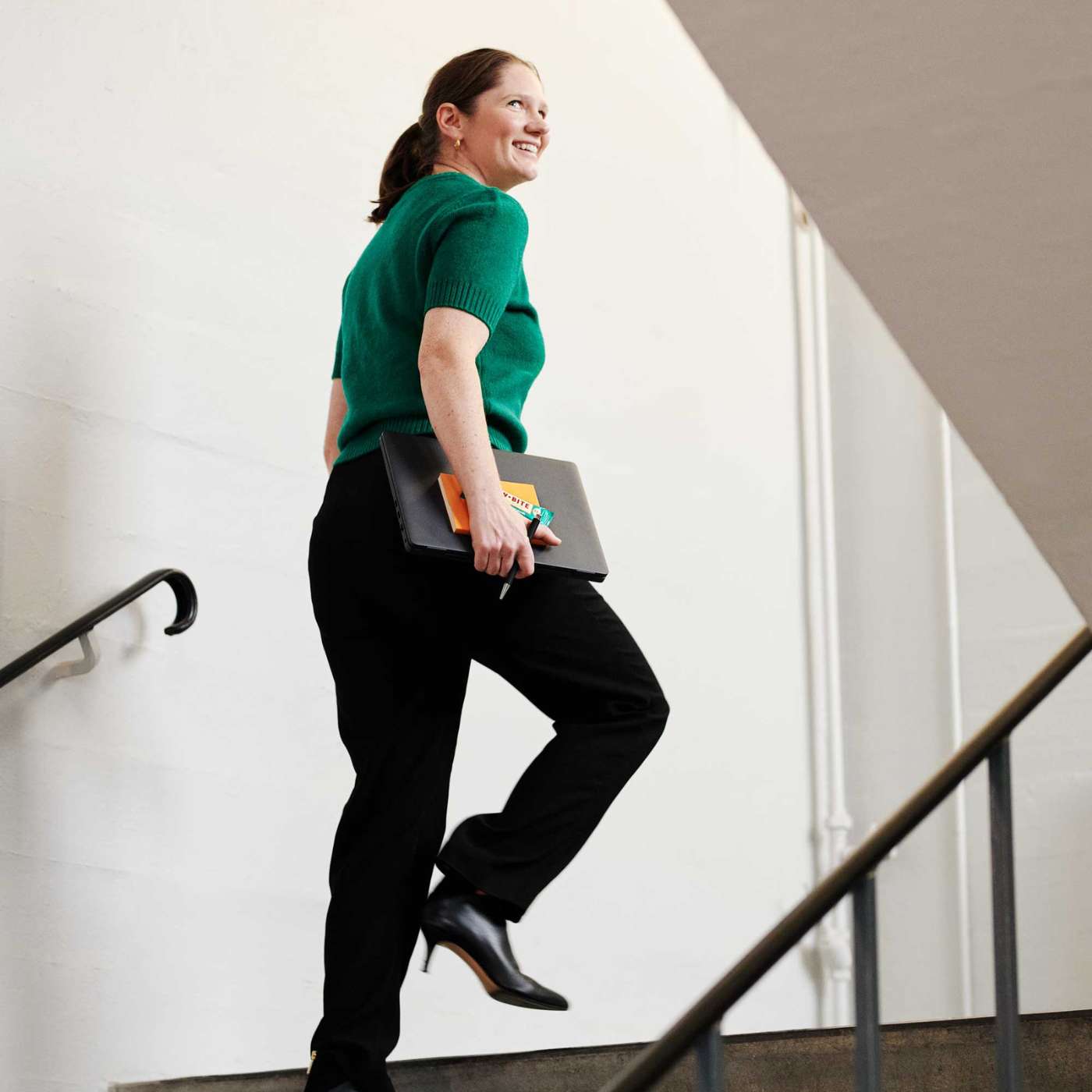 kvinna som går uppför trappan och håller en rawbite