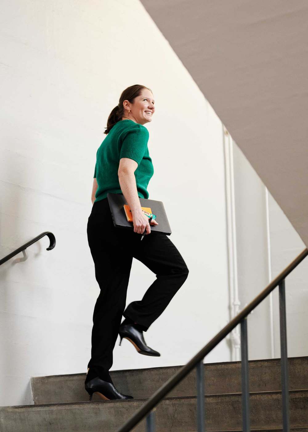 kvinna som går uppför trappan och håller en rawbite