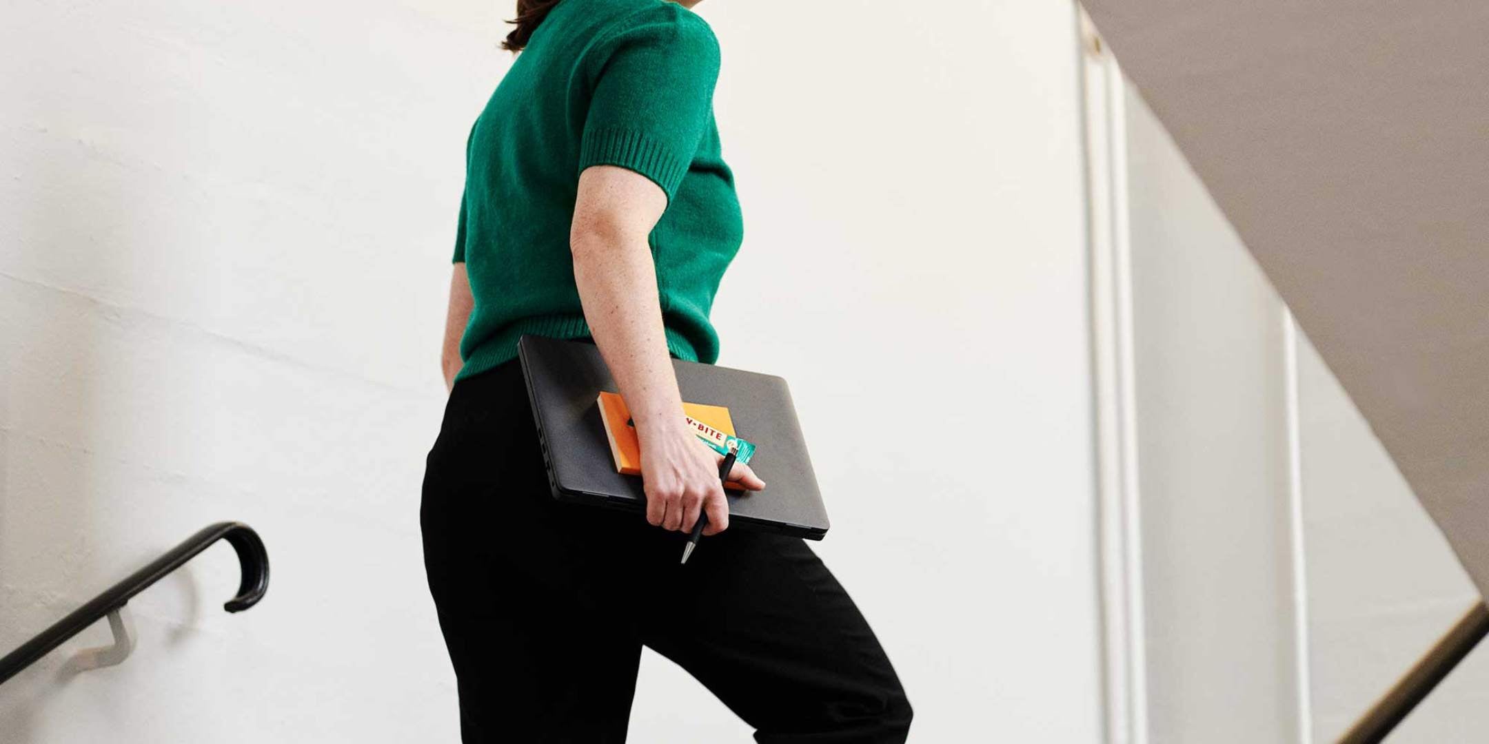 kvinna som går uppför trappan och håller en rawbite